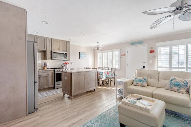 living room with ceiling fan and light wood-type flooring