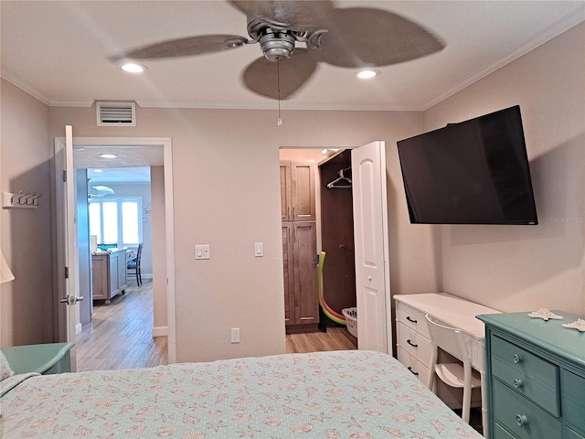 bedroom with crown molding, ceiling fan, and light hardwood / wood-style flooring