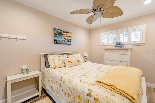 bedroom featuring ceiling fan, ornamental molding, and light wood-type flooring