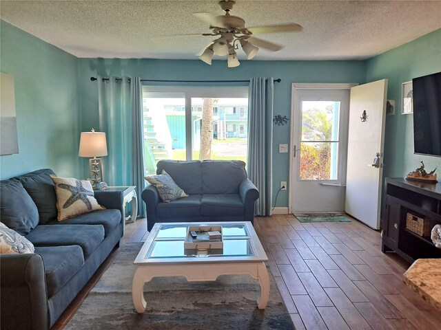 living room featuring a textured ceiling, ceiling fan, and hardwood / wood-style floors