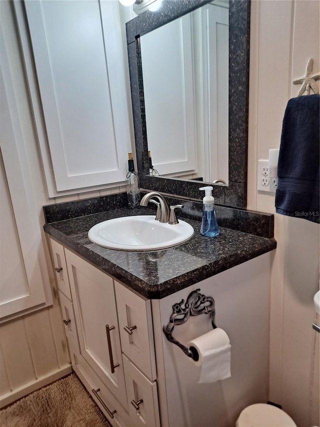 bathroom with vanity with extensive cabinet space and toilet