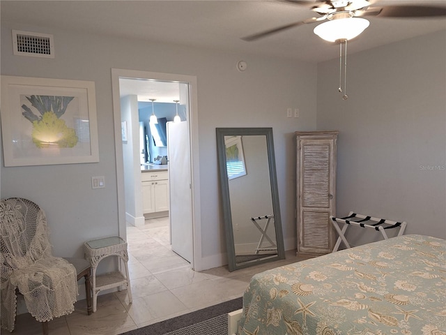 bedroom featuring ensuite bath, ceiling fan, and white fridge