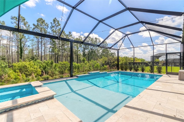 view of swimming pool with a patio, an in ground hot tub, and glass enclosure