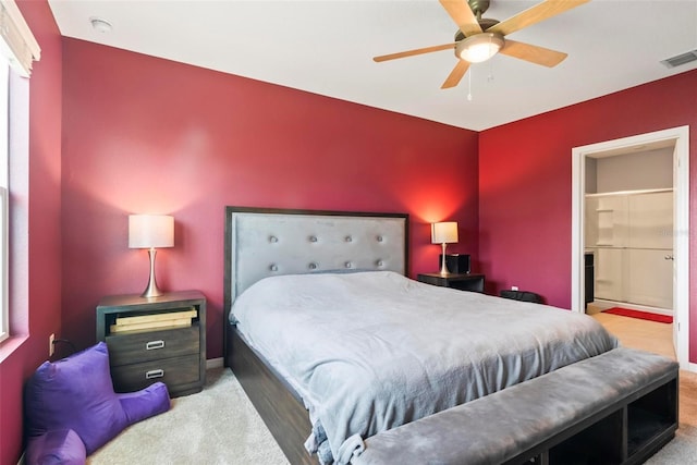 carpeted bedroom with ceiling fan and ensuite bath