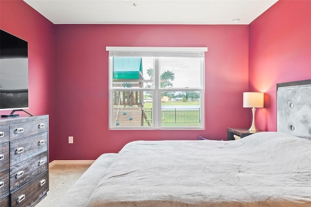 bedroom with light colored carpet and multiple windows