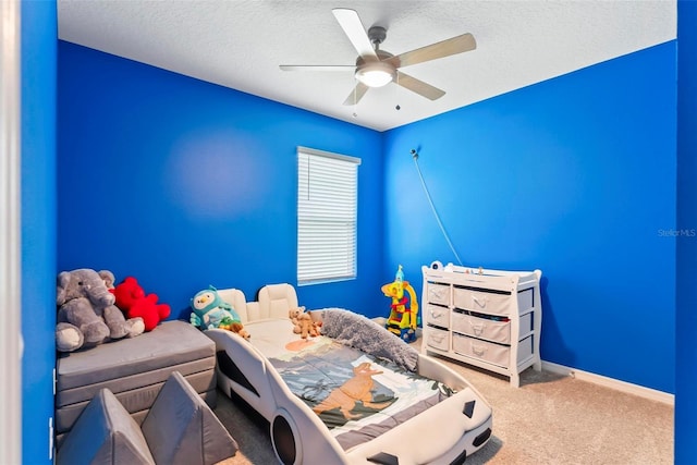 bedroom featuring a textured ceiling, ceiling fan, and carpet