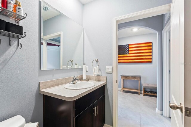 bathroom featuring tile patterned flooring, vanity, and toilet