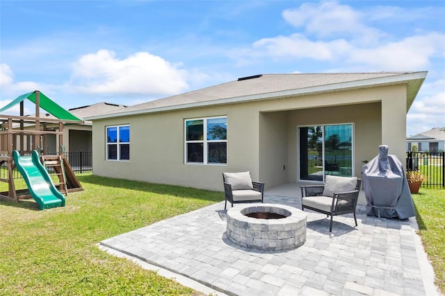 rear view of house featuring a playground, a lawn, a patio area, and a fire pit