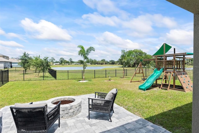 view of play area with a water view, a patio area, a fire pit, and a lawn