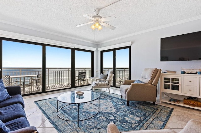 tiled living room featuring ceiling fan, crown molding, a textured ceiling, and a water view