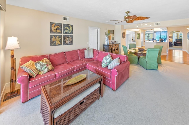 carpeted living room with ceiling fan