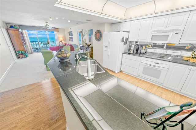 kitchen featuring white appliances, light hardwood / wood-style flooring, ceiling fan, and sink