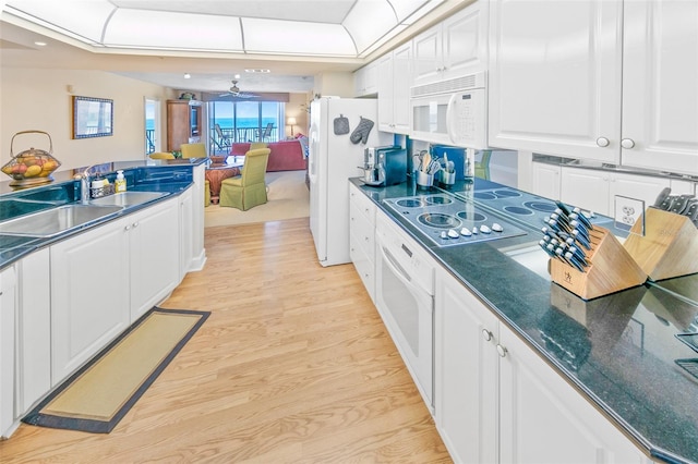 kitchen featuring white appliances, sink, ceiling fan, light hardwood / wood-style floors, and white cabinetry