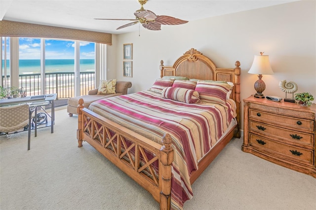 carpeted bedroom with access to exterior, a water view, and ceiling fan