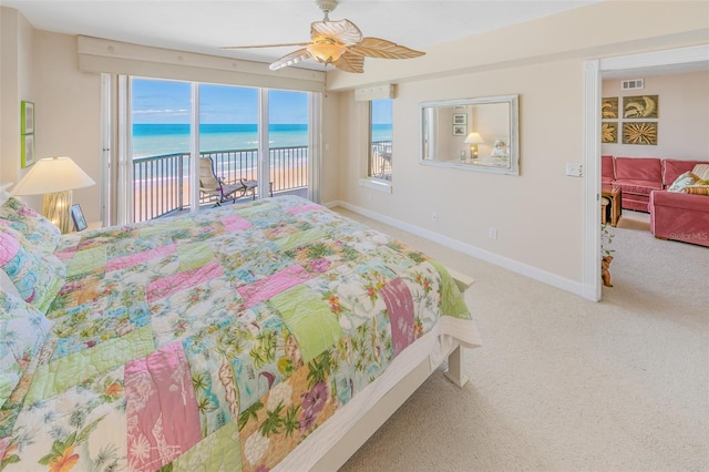 carpeted bedroom featuring ceiling fan, a water view, and access to outside