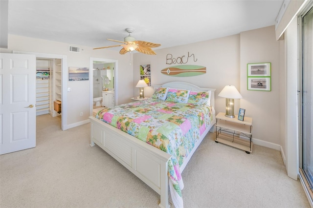 bedroom with connected bathroom, ceiling fan, a closet, and light carpet