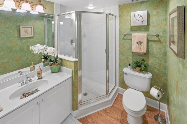 bathroom featuring hardwood / wood-style flooring, vanity, toilet, and walk in shower