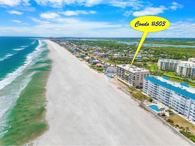 bird's eye view with a water view and a beach view