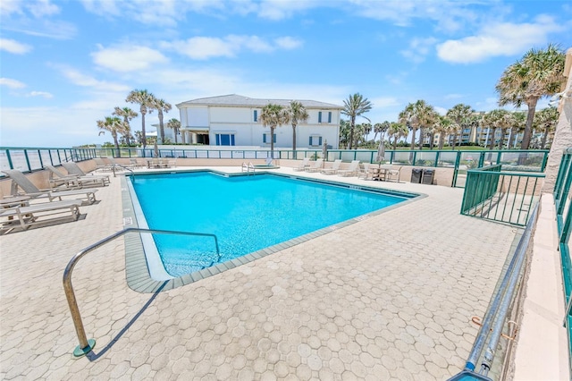 view of swimming pool featuring a patio and a water view