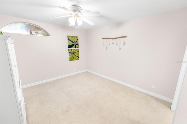 spare room featuring ceiling fan and light carpet