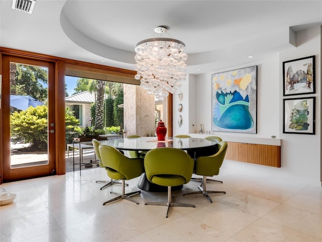 dining space with a raised ceiling, light tile patterned floors, a wealth of natural light, and an inviting chandelier