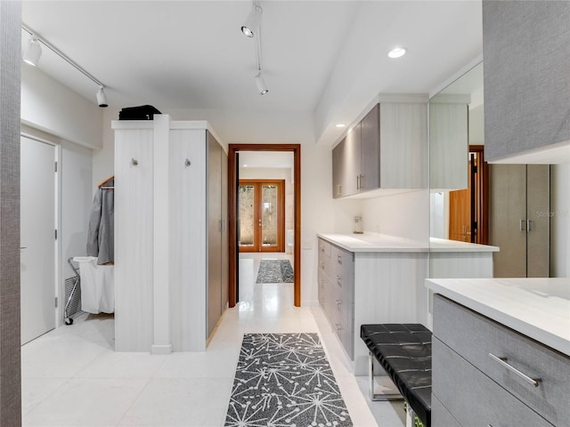 interior space with tile patterned floors, vanity, and rail lighting