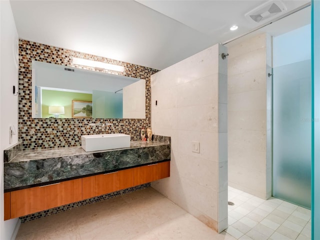 bathroom featuring decorative backsplash, vanity, and tile walls