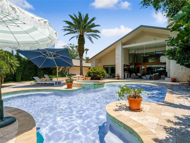 view of swimming pool featuring an in ground hot tub and a patio