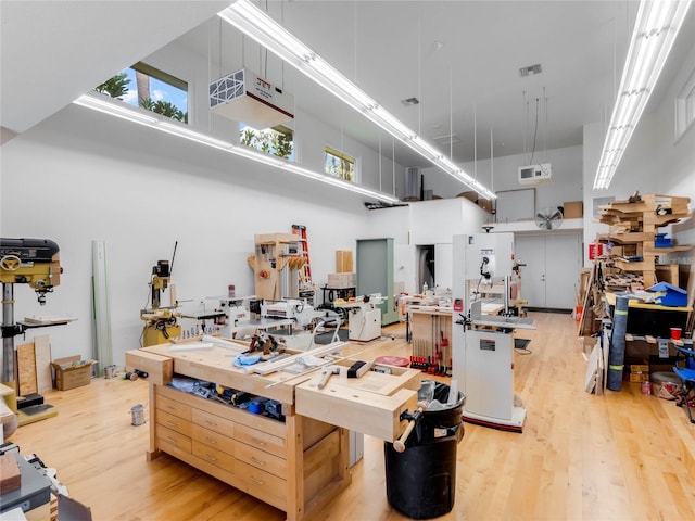 kitchen with a towering ceiling, light hardwood / wood-style floors, and a kitchen island