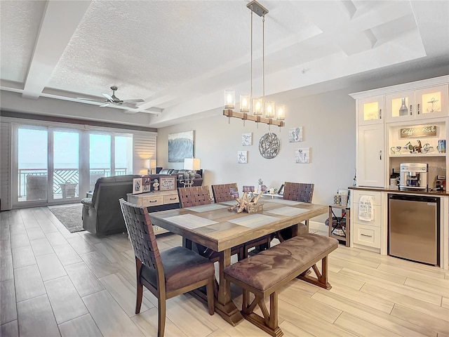 dining room featuring beamed ceiling, a textured ceiling, wood tiled floor, and ceiling fan with notable chandelier