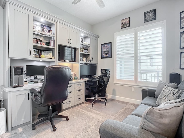 office area featuring light colored carpet, baseboards, and ceiling fan