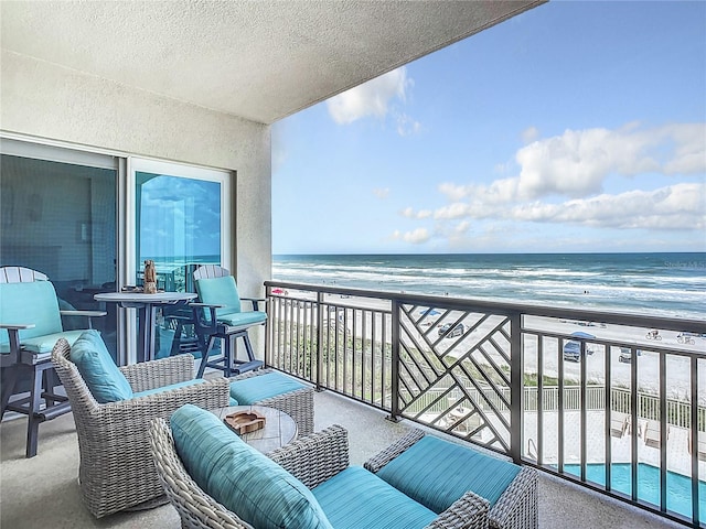 balcony featuring a beach view and a water view