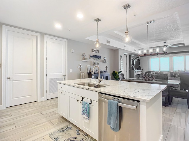 kitchen with a sink, light stone countertops, open floor plan, stainless steel dishwasher, and a kitchen island with sink