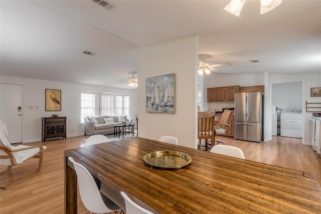 dining room featuring ceiling fan, light wood-type flooring, lofted ceiling, and a textured ceiling