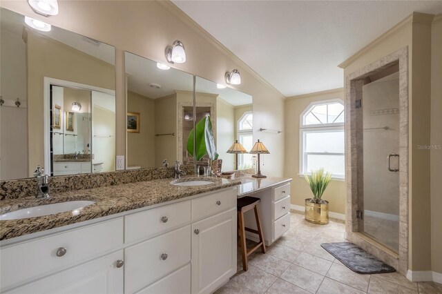 bathroom with vanity, lofted ceiling, tile patterned flooring, ornamental molding, and a shower with shower door