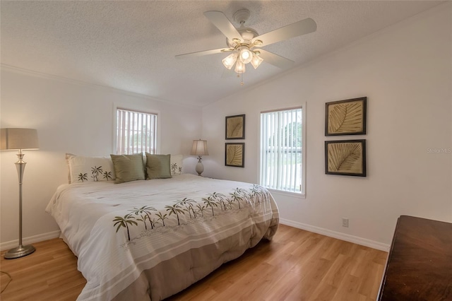 bedroom with ceiling fan, light hardwood / wood-style floors, lofted ceiling, and multiple windows