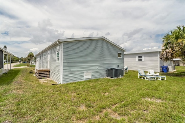 view of side of home featuring a yard and central AC unit