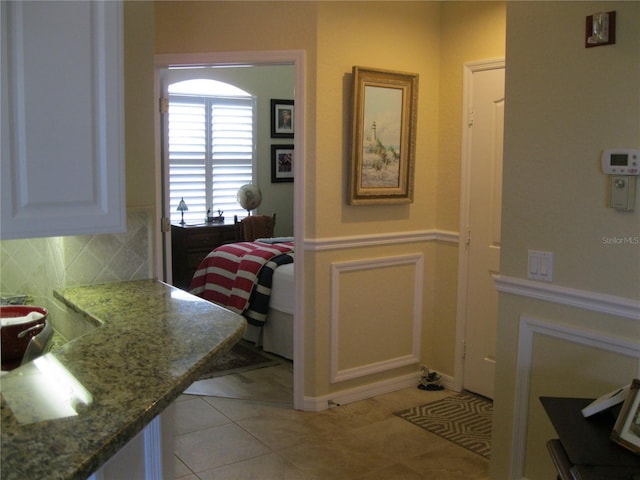 interior space featuring decorative backsplash and tile patterned flooring