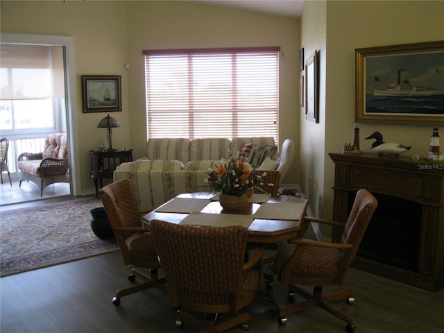 dining space with hardwood / wood-style flooring, a wealth of natural light, and lofted ceiling