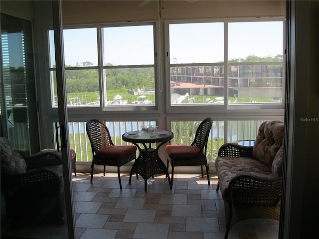 sunroom featuring a water view