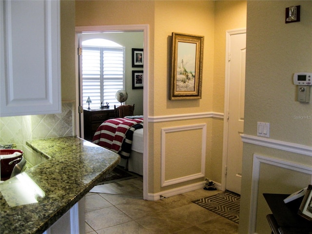 434 Bouchelle Dr Unit 304, New Smyrna Beach, FL 32169 - kitchen featuring tasteful backsplash, white cabinets, light tile patterned flooring, and dark stone countertops