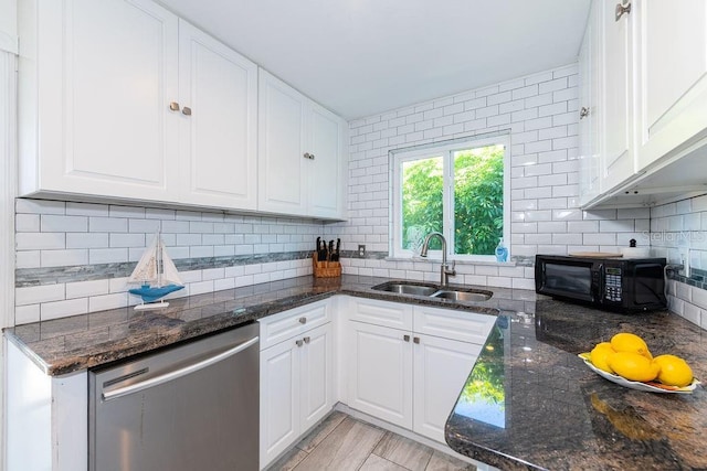 kitchen featuring tasteful backsplash, stainless steel dishwasher, sink, dark stone countertops, and white cabinets