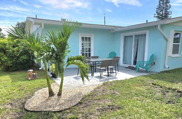 back of house with a patio area and a yard