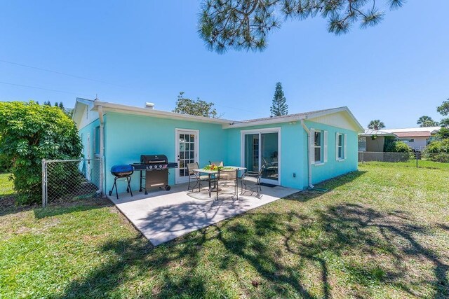 rear view of house featuring a patio and a lawn