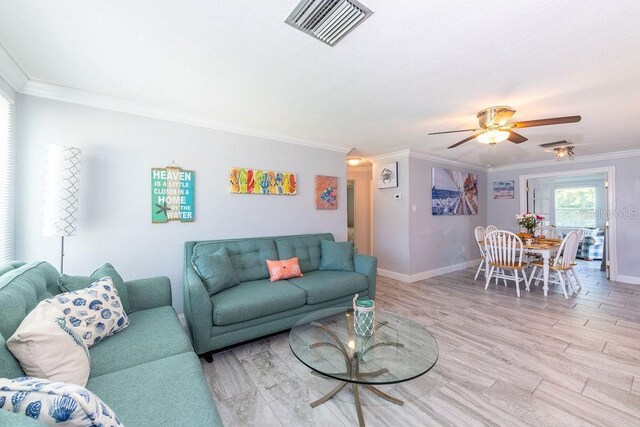 living room with ceiling fan, ornamental molding, and light hardwood / wood-style flooring