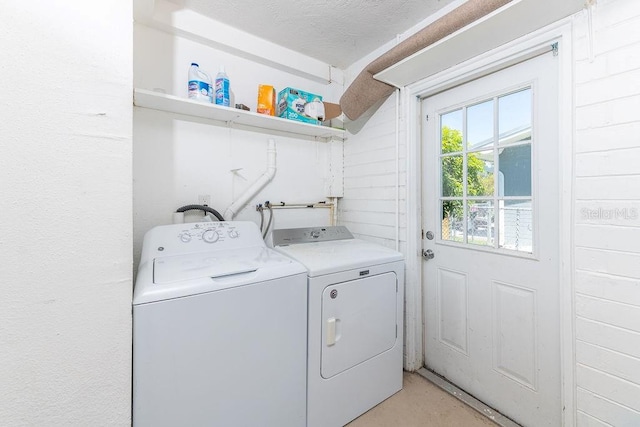 washroom with separate washer and dryer and a textured ceiling