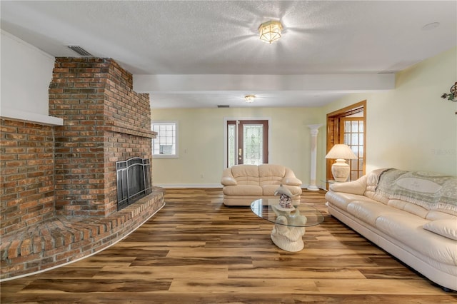 living room featuring hardwood / wood-style floors, a fireplace, and a textured ceiling