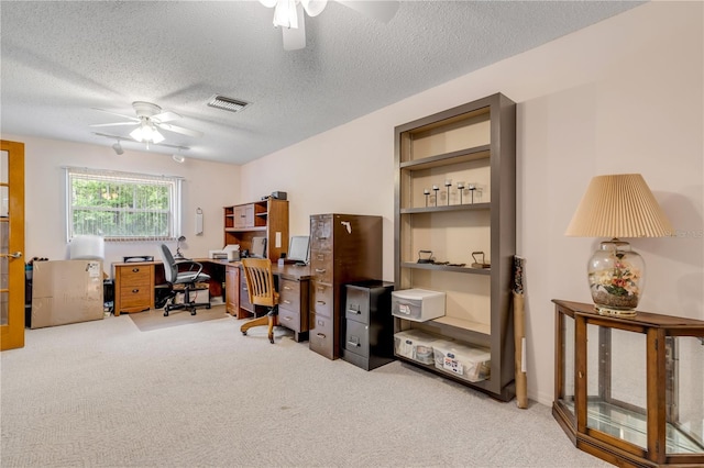 carpeted office space with ceiling fan and a textured ceiling