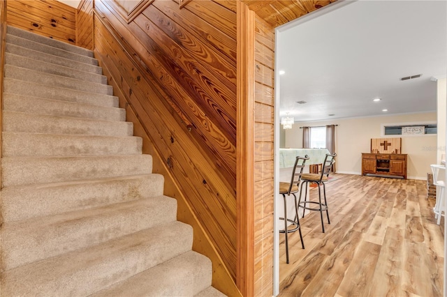 staircase with wood walls and wood-type flooring