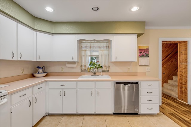 kitchen with stainless steel dishwasher, crown molding, sink, light tile patterned floors, and white cabinets